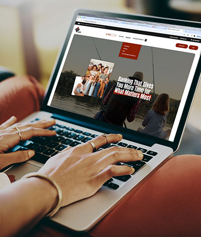 Person using a laptop to look at the new cs.bank website