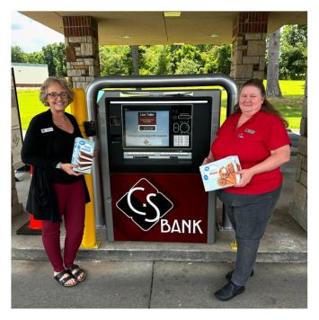 CS Bank staff in front of live teller machine